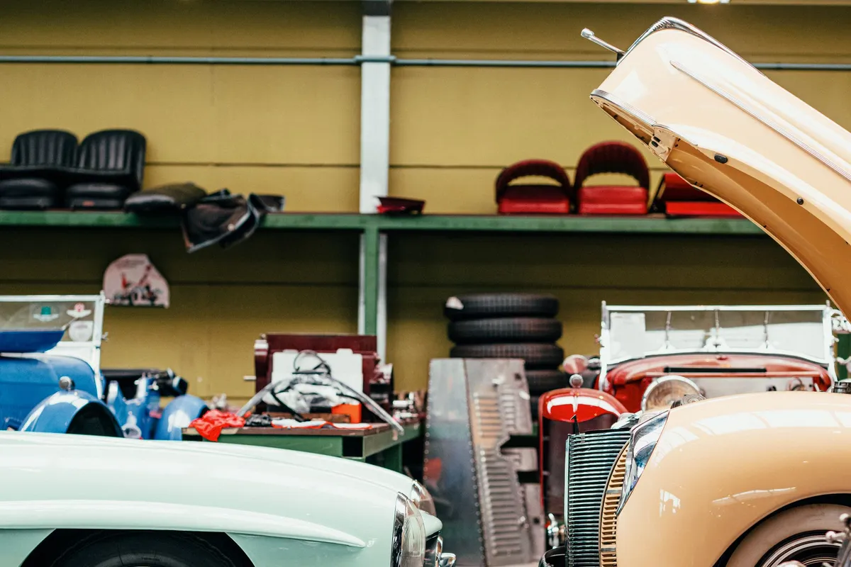 Vintage cars with open hoods in a classic automotive workshop